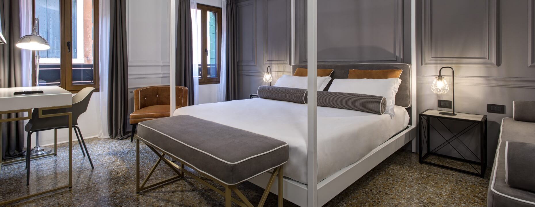 Camera d'hotel con letto a baldacchino e arredi eleganti.