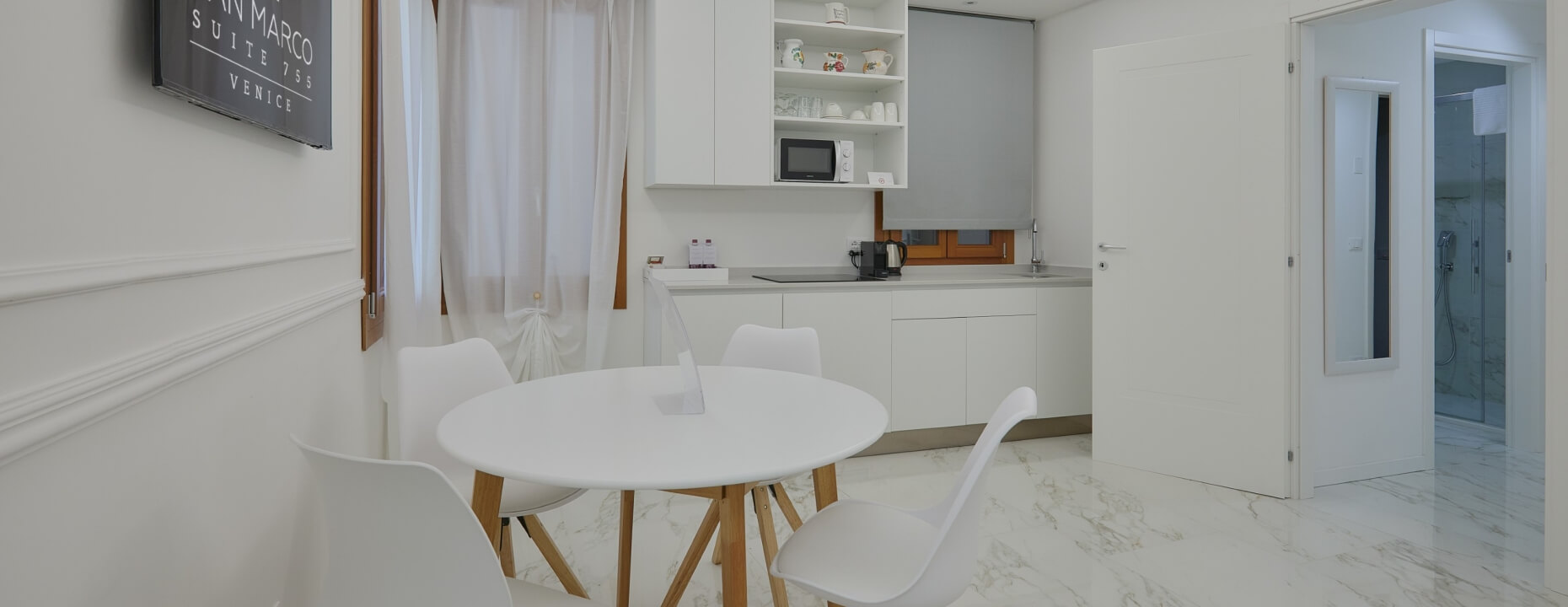 Suite con angolo cottura, tavolo rotondo e bagno con doccia.