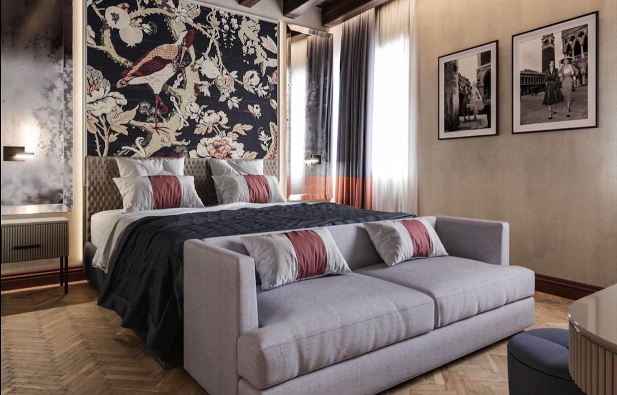 Camera accogliente con letto grande, divano grigio, tavolino, fotografie in bianco e nero e pavimento a spina di pesce.
