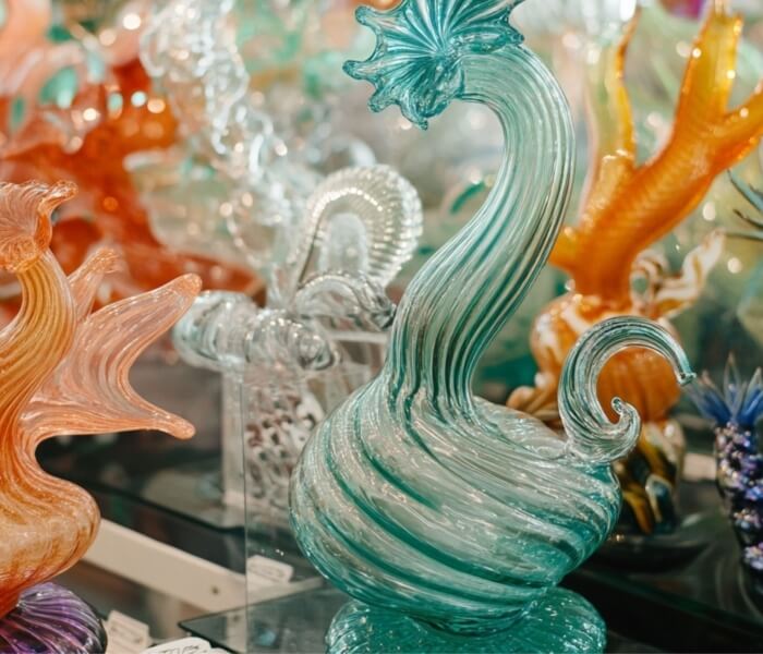 Sculture di vetro colorate, con un uccello turchese in primo piano.