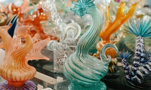 Collezione di sculture in vetro colorato su mensole.