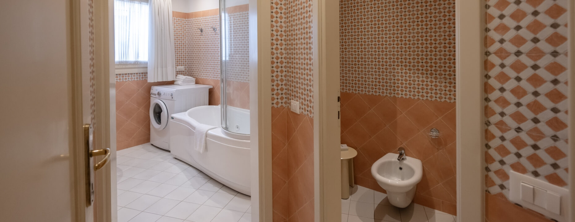 Bagno con vasca, lavatrice, bidet e pareti a diamante.