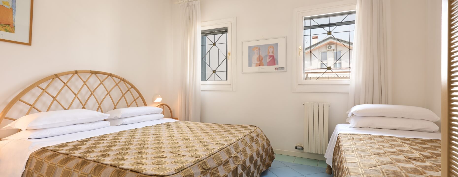 Camera d'hotel con un letto matrimoniale e un letto singolo.