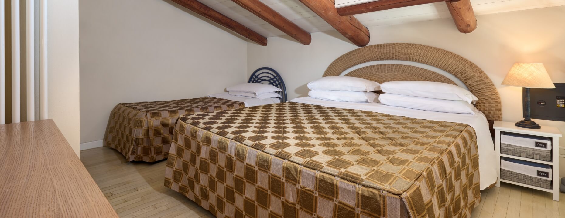 Camera d'hotel con due letti, testate diverse e decorazioni.