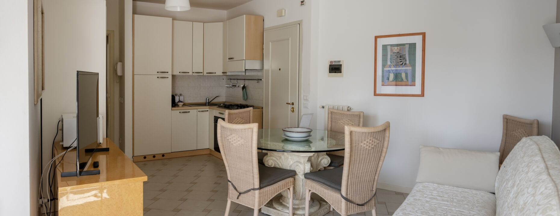 Cucina e soggiorno in un monolocale con tavolo e divano.