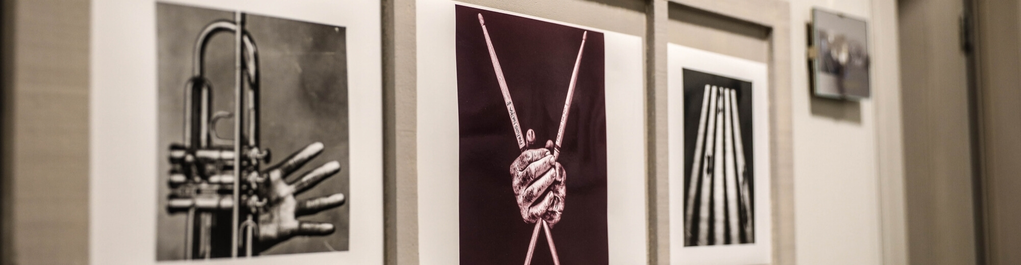 Collezione di fotografie incorniciate di strumenti musicali, con immagini in bianco e nero e una a colori su sfondo bianco.