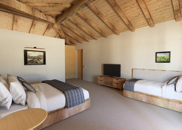 Camera d'hotel con due letti, travi a vista e decorazioni moderne.