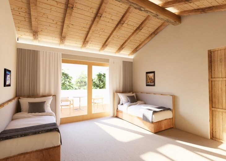 Camera d'hotel con due letti singoli e patio esterno.