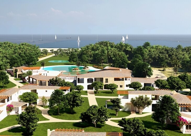 Vista aerea di un resort con piscina, spiaggia e barche a vela.