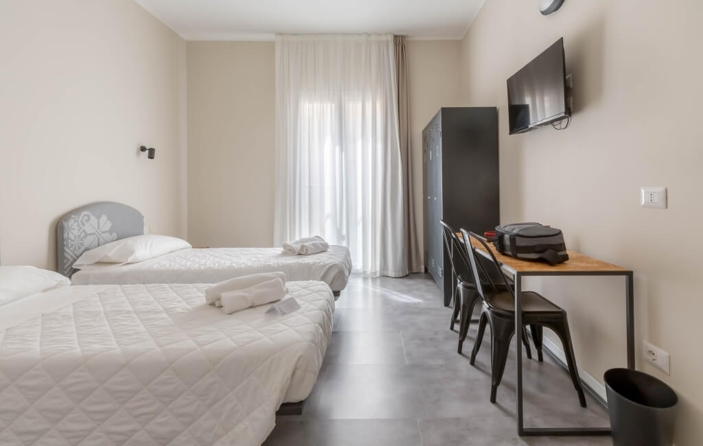 room with TV, desk and locker