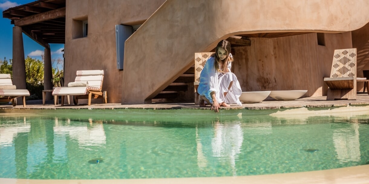 Donna che sfiora l'acqua della piscina con la mano