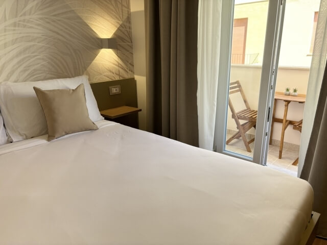 letto matrimoniale e tavolo nel balcone della camera