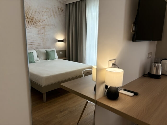 specchio che riflette il letto matrimoniale della camera deluxe