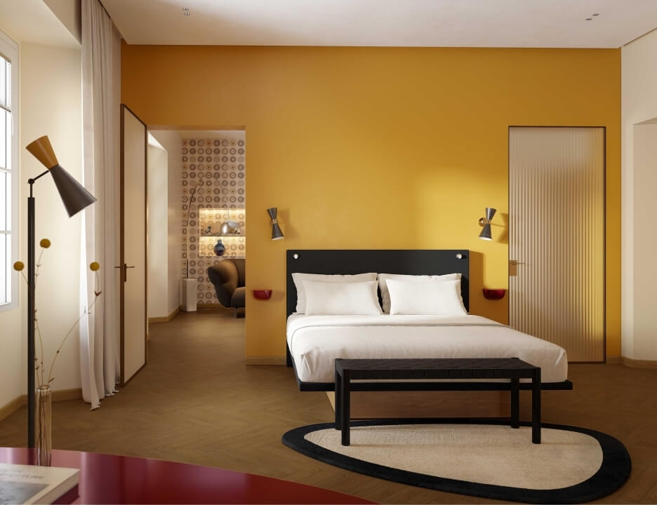 Camera da letto serena con parete gialla, letto centrale, biancheria bianca e tappeto ovale crema con bordo nero.