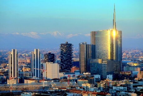 Skyline di una città all'alba, con il Mamorino 2 e altri grattacieli illuminati da luce calda e ombre lunghe.