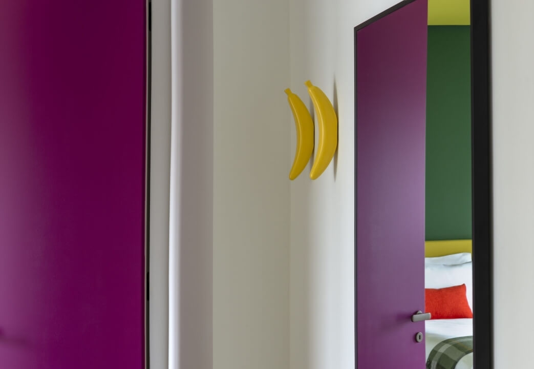 Una serie di porte colorate con decorazioni giocose, su uno sfondo bianco, creando un ambiente vivace e creativo.