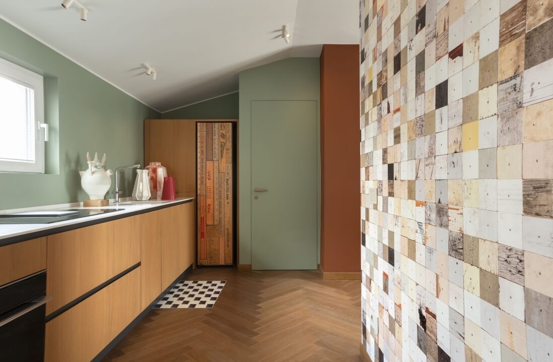 Cucina moderna con controsoffitto bianco, marmo bianco, armadietti in legno di betulla e parete decorativa in piastrelle.