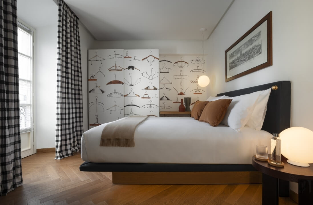 Camera da letto serena con letto bianco, testiera nera, biancheria coordinata e decorazioni accoglienti.