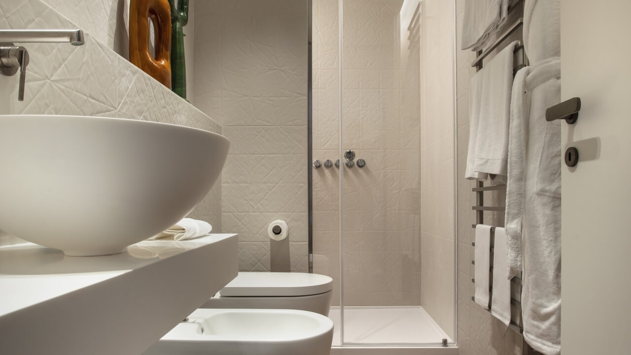 Modern minimalist bathroom featuring white fixtures, a sink, toilet, shower, bathtub, and decorative elements.