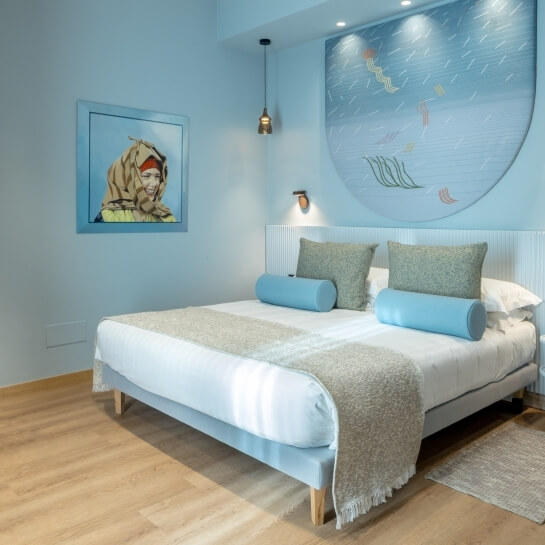 Chambre d'hôtel avec lit, œuvres d'art et éléments décoratifs.