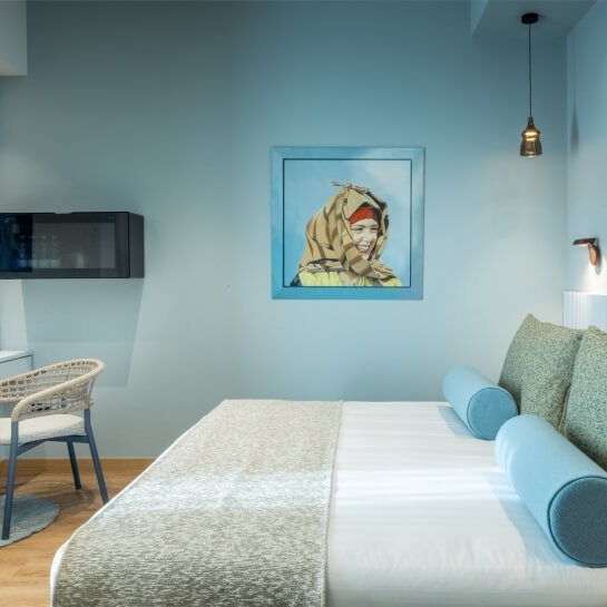 Chambre d'hôtel avec lit, peinture, micro-ondes et chaise.