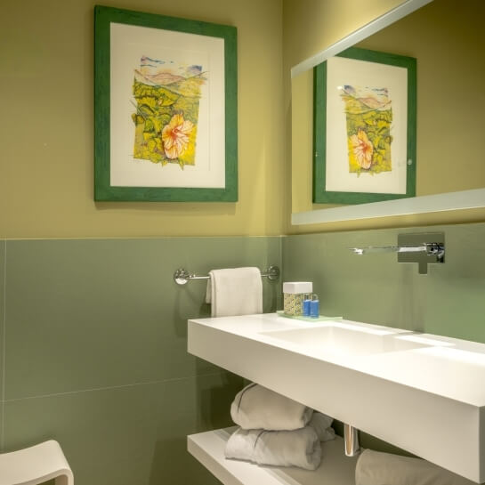 Vanité de salle de bain avec lavabo, miroir et serviettes.