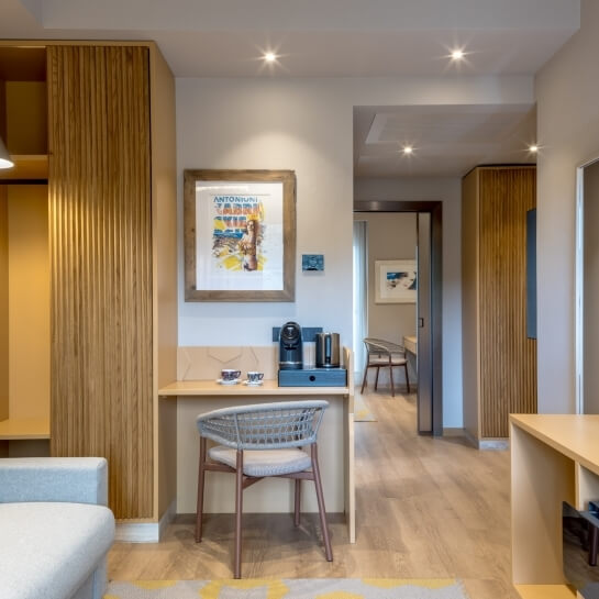 Salon avec canapé gris, bureau en bois et armoire.