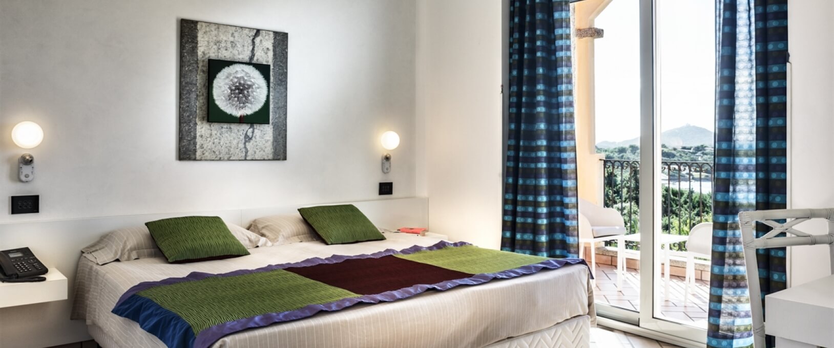 Chambre sereine avec lit blanc, balcon, vue sur la nature, et décor élégant, créant une atmosphère paisible.