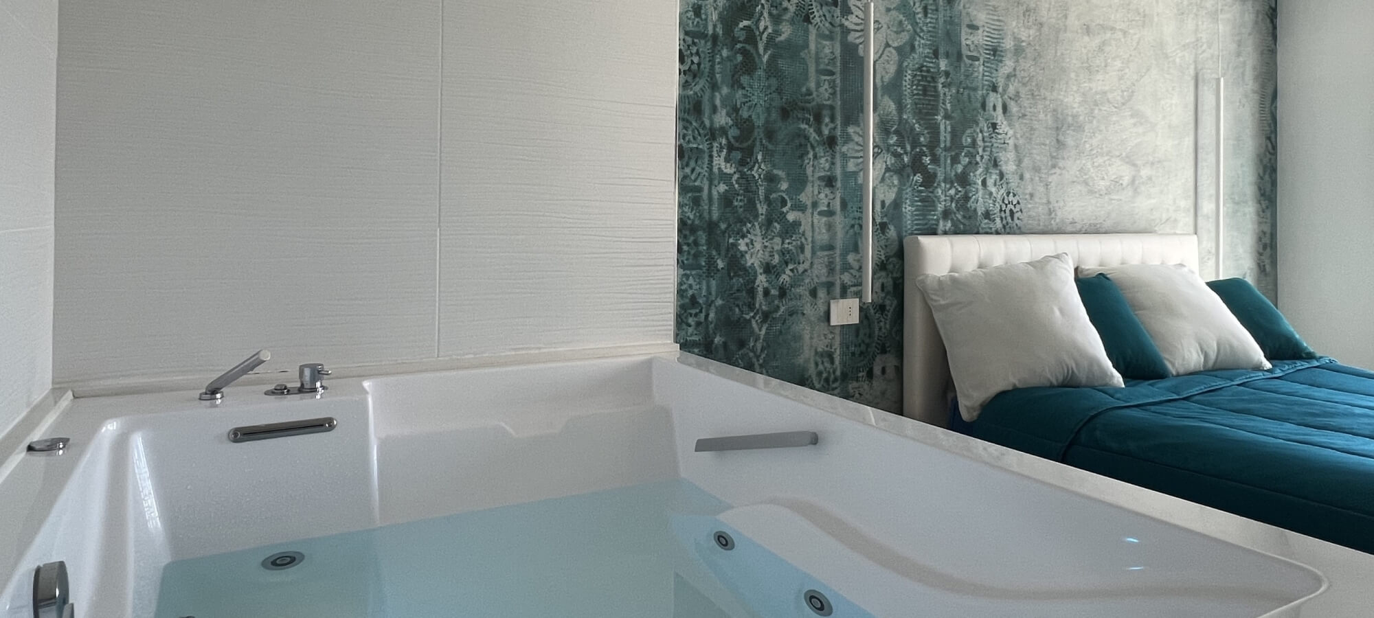 vasca idromassaggio con acqua con letto accanto