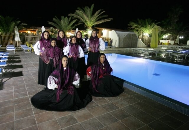 Girls in traditional Sardinian costume at the Torre del Porticciolo